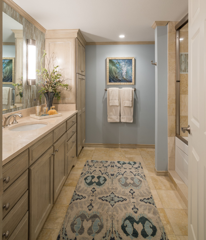 Example of a large transitional beige tile and stone tile marble floor bathroom design in Dallas with recessed-panel cabinets, distressed cabinets, a one-piece toilet, blue walls, an undermount sink and marble countertops
