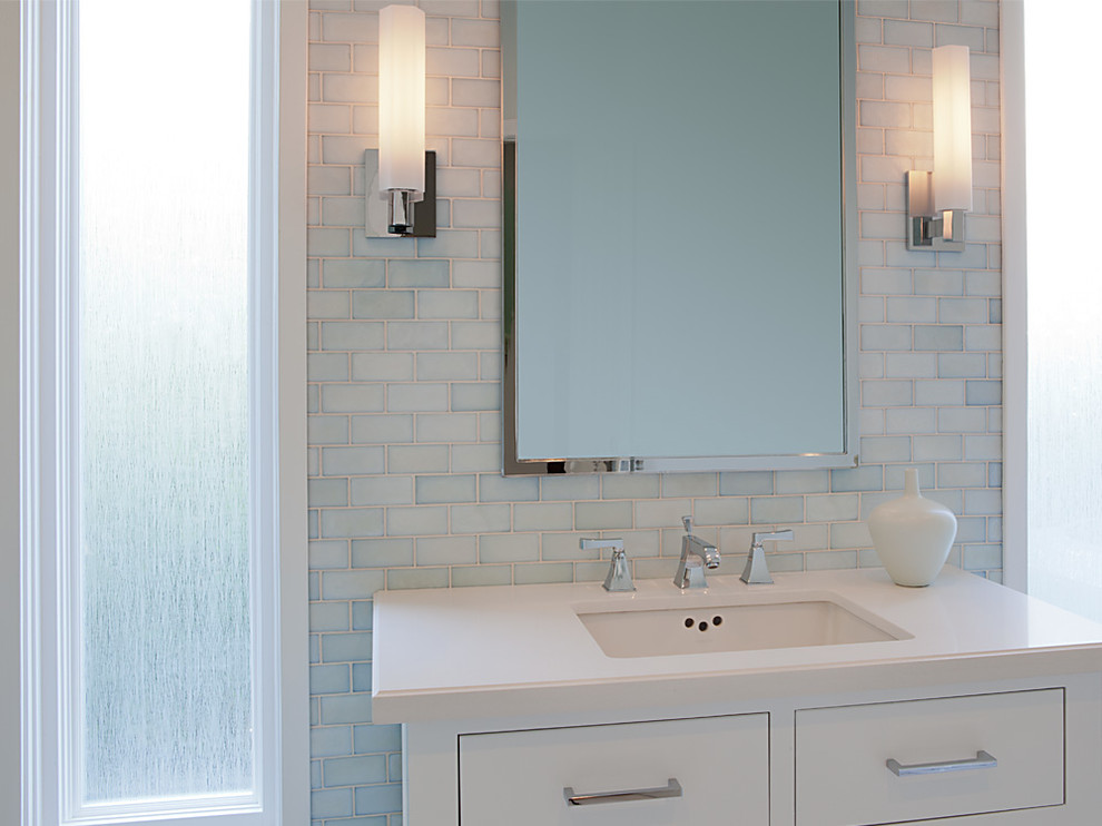 Klassisk inredning av ett mellanstort badrum med dusch, med vita skåp, blå kakel, glaskakel, blå väggar, klinkergolv i porslin, ett undermonterad handfat, luckor med infälld panel, en öppen dusch och bänkskiva i kvarts