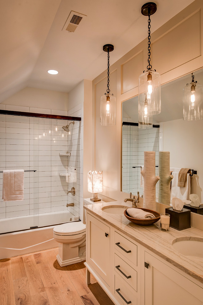インディアナポリスにある高級な中くらいなトランジショナルスタイルのおしゃれなバスルーム (浴槽なし) (フラットパネル扉のキャビネット、白いキャビネット、アルコーブ型浴槽、シャワー付き浴槽	、白いタイル、ベージュの壁、淡色無垢フローリング、アンダーカウンター洗面器、分離型トイレ、引戸のシャワー) の写真