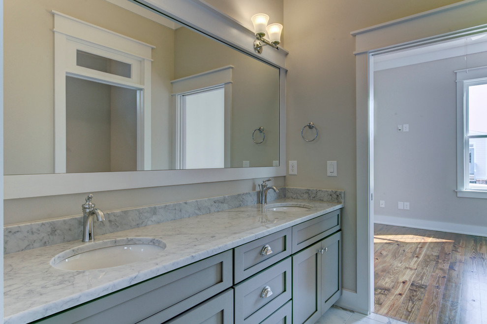 Immagine di una stanza da bagno con doccia country di medie dimensioni con lavabo sottopiano, ante in stile shaker, ante grigie, top in marmo, piastrelle bianche, piastrelle in ceramica, pareti grigie e pavimento con piastrelle in ceramica