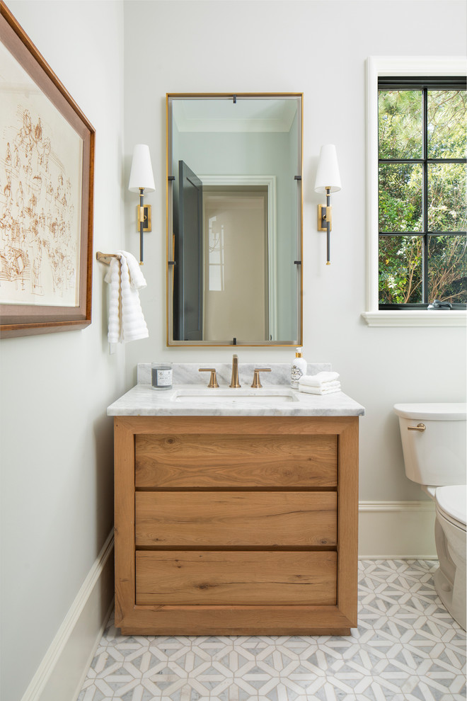 Стильный дизайн: ванная комната среднего размера в стиле неоклассика (современная классика) с фасадами островного типа, фасадами цвета дерева среднего тона, бежевыми стенами, мраморной столешницей и белой столешницей - последний тренд