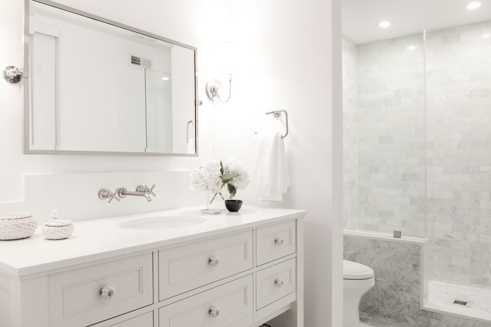 Idee per una piccola stanza da bagno con doccia chic con ante in stile shaker, ante bianche, WC a due pezzi, piastrelle bianche, piastrelle in ceramica, pareti bianche, pavimento con piastrelle a mosaico, lavabo sottopiano e top in superficie solida