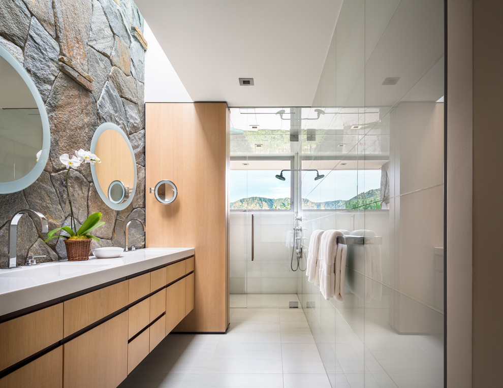 Foto på ett stort retro en-suite badrum, med ett integrerad handfat, en kantlös dusch, släta luckor, skåp i ljust trä, marmorbänkskiva, vit kakel, glaskakel, klinkergolv i keramik, vita väggar och vitt golv
