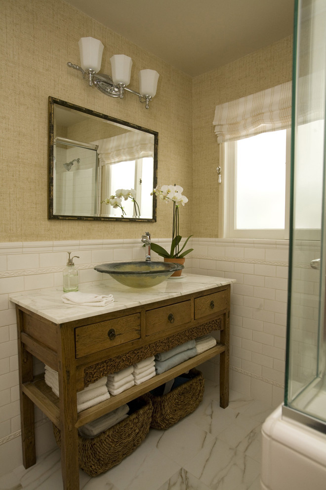 Aménagement d'une salle de bain classique en bois brun avec une vasque, un placard en trompe-l'oeil, un plan de toilette en marbre, une douche d'angle, un carrelage blanc, des carreaux de porcelaine, un mur beige et un sol en marbre.