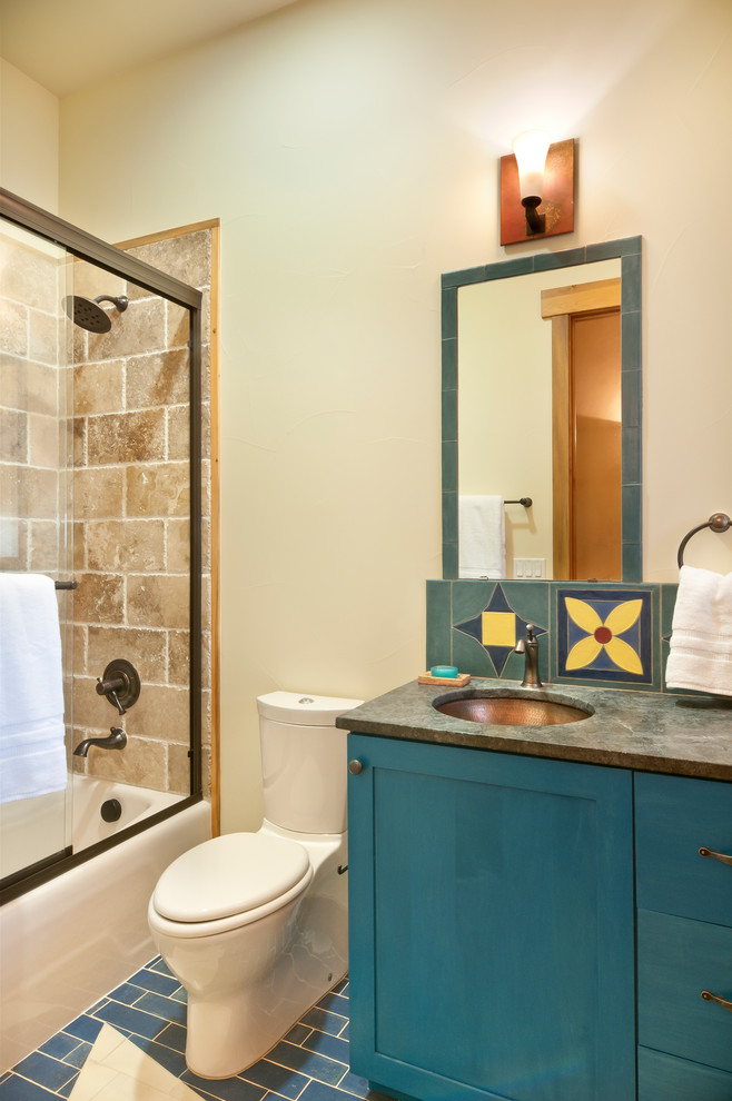 Idéer för att renovera ett litet amerikanskt badrum, med skåp i shakerstil, blå skåp, ett badkar i en alkov, en toalettstol med separat cisternkåpa, ett undermonterad handfat och bänkskiva i täljsten