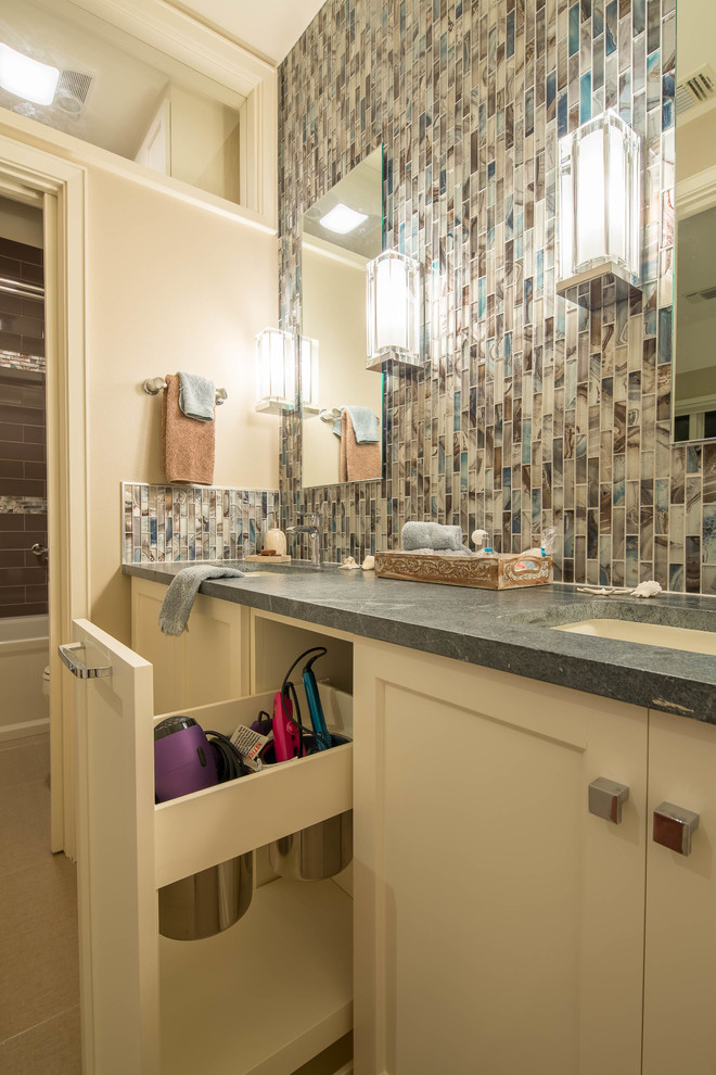 Photo of a medium sized modern bathroom in Austin with a submerged sink, shaker cabinets, white cabinets, soapstone worktops, an alcove bath, a shower/bath combination, multi-coloured tiles, mosaic tiles, beige walls and porcelain flooring.