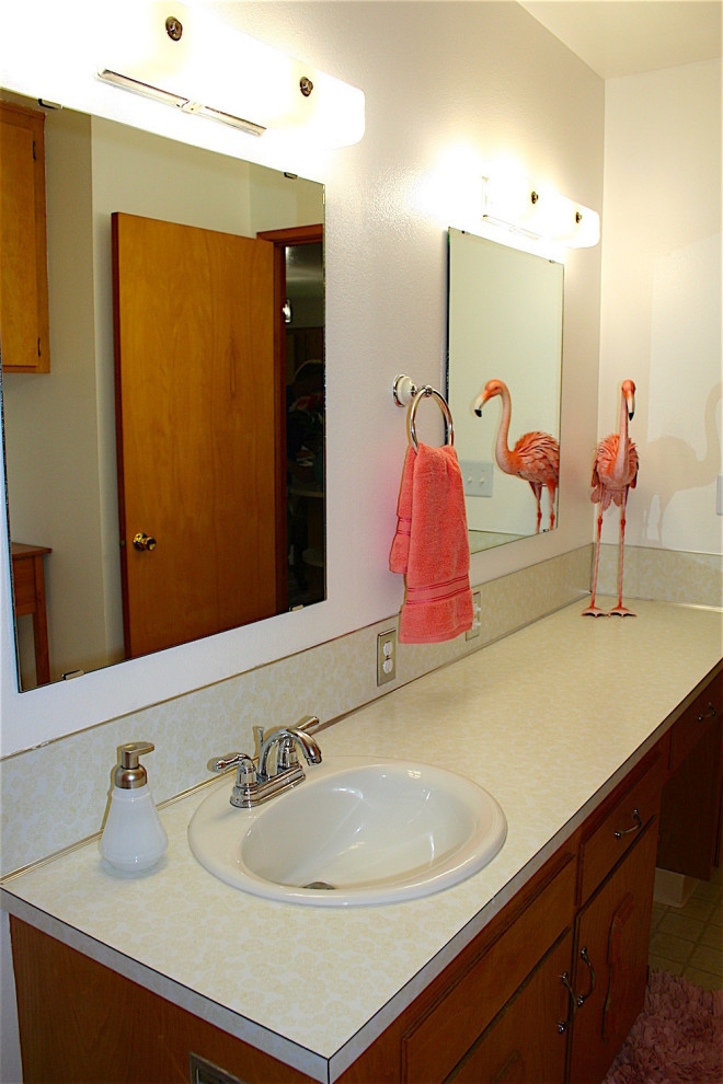 Example of a mid-sized eclectic yellow tile and ceramic tile vinyl floor, yellow floor and single-sink bathroom design in Other with raised-panel cabinets, medium tone wood cabinets, a two-piece toilet, white walls, a drop-in sink, laminate countertops, yellow countertops and a built-in vanity