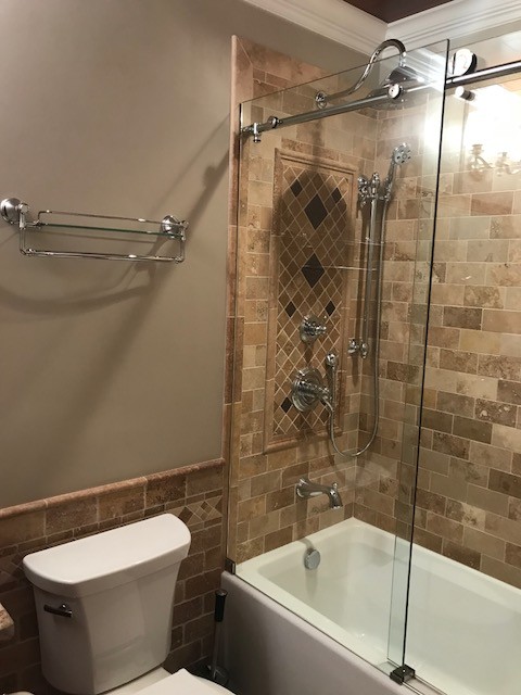 Design ideas for a medium sized traditional family bathroom in Other with raised-panel cabinets, brown cabinets, an alcove bath, a shower/bath combination, a two-piece toilet, beige tiles, travertine tiles, beige walls, travertine flooring, a submerged sink, granite worktops, multi-coloured floors and a sliding door.