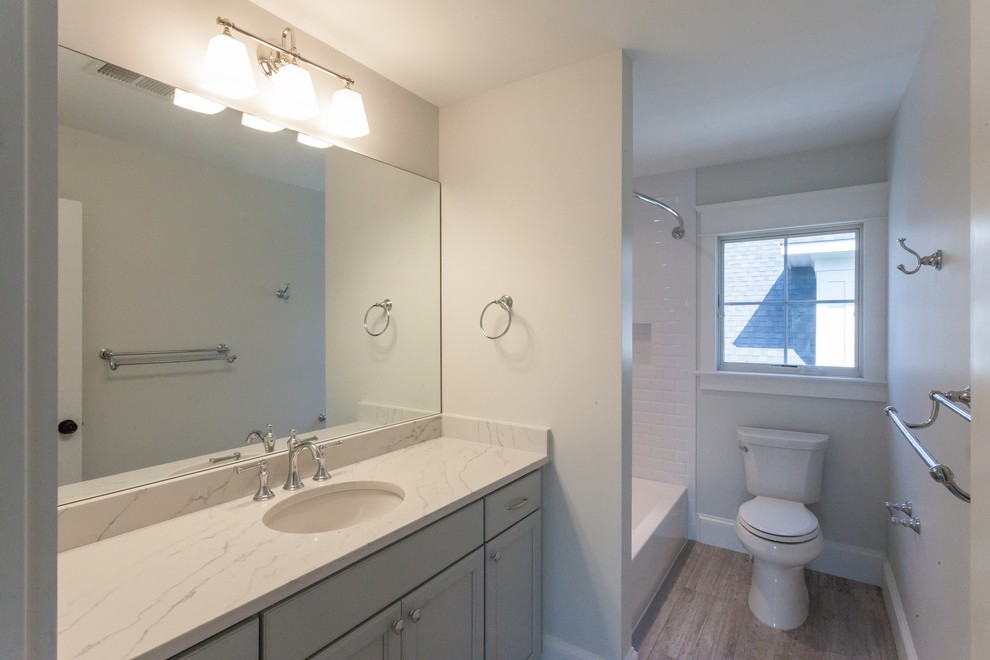 Example of a farmhouse white tile and subway tile porcelain tile and blue floor bathroom design in DC Metro with recessed-panel cabinets, blue cabinets, gray walls, an undermount sink and white countertops