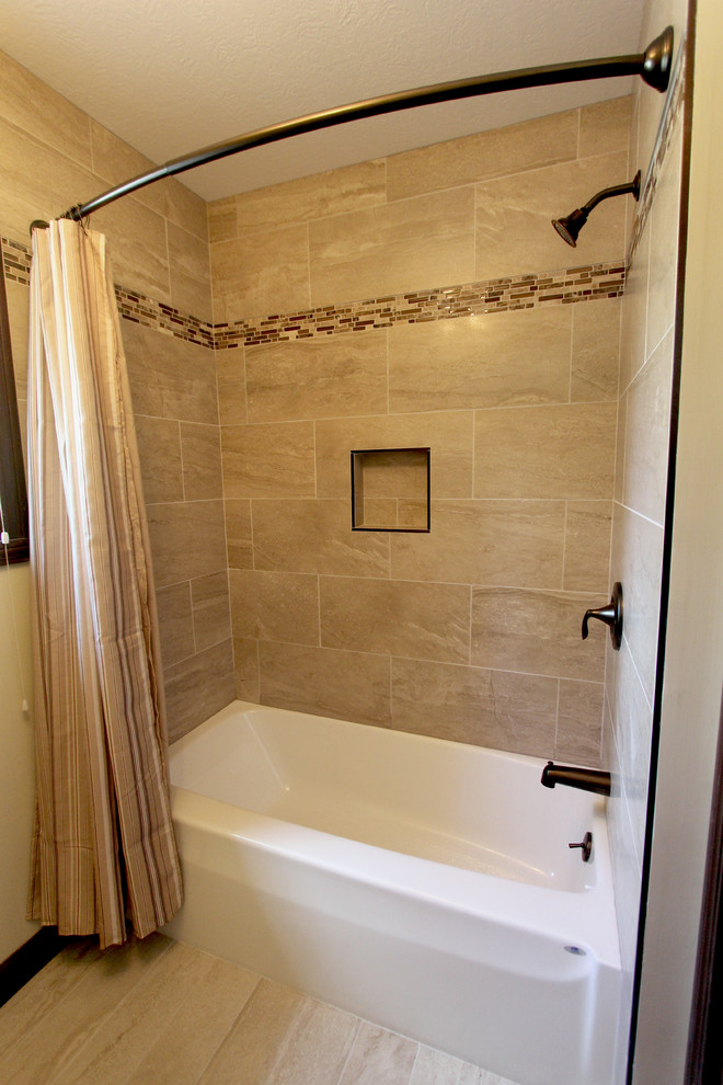 Foto på ett mellanstort vintage badrum, med ett undermonterad handfat, skåp i mellenmörkt trä, granitbänkskiva, ett badkar i en alkov, porslinskakel, beige väggar och klinkergolv i porslin