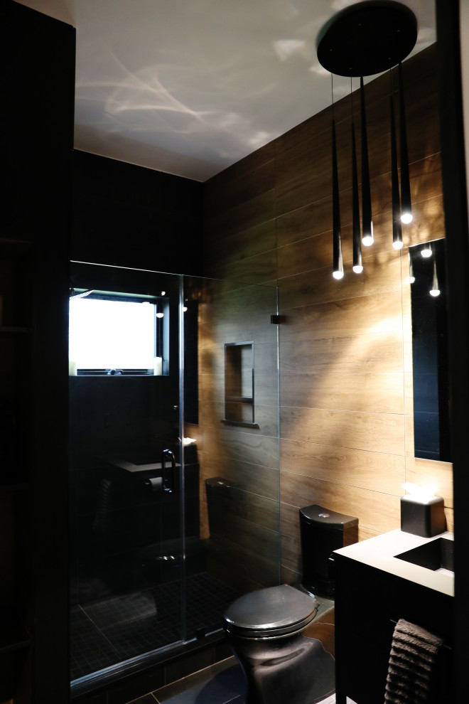 Ispirazione per una piccola stanza da bagno design con doccia alcova, WC monopezzo, piastrelle marroni, pareti marroni, pavimento in gres porcellanato, lavabo integrato, pavimento nero e top nero