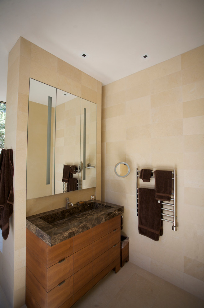 Immagine di una piccola stanza da bagno contemporanea con lavabo integrato, ante lisce, ante in legno scuro, top in granito e piastrelle beige