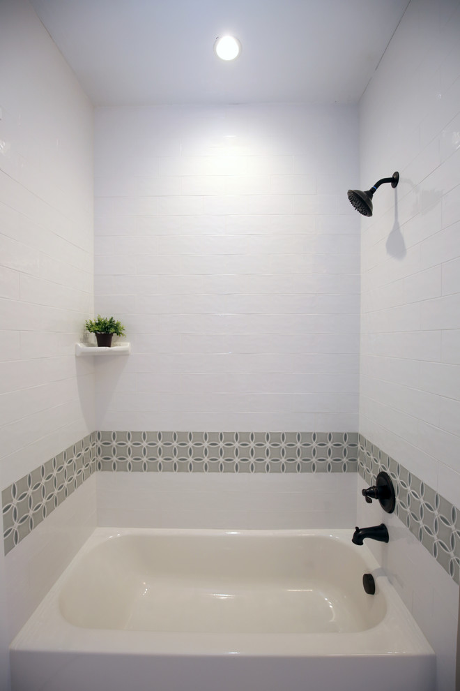 Foto på ett mellanstort vintage vit badrum, med vita skåp, ett badkar i en alkov, en dusch/badkar-kombination, ett undermonterad handfat, dusch med duschdraperi, luckor med infälld panel, en toalettstol med separat cisternkåpa, grå kakel, keramikplattor, beige väggar, klinkergolv i porslin, bänkskiva i kvartsit och vitt golv