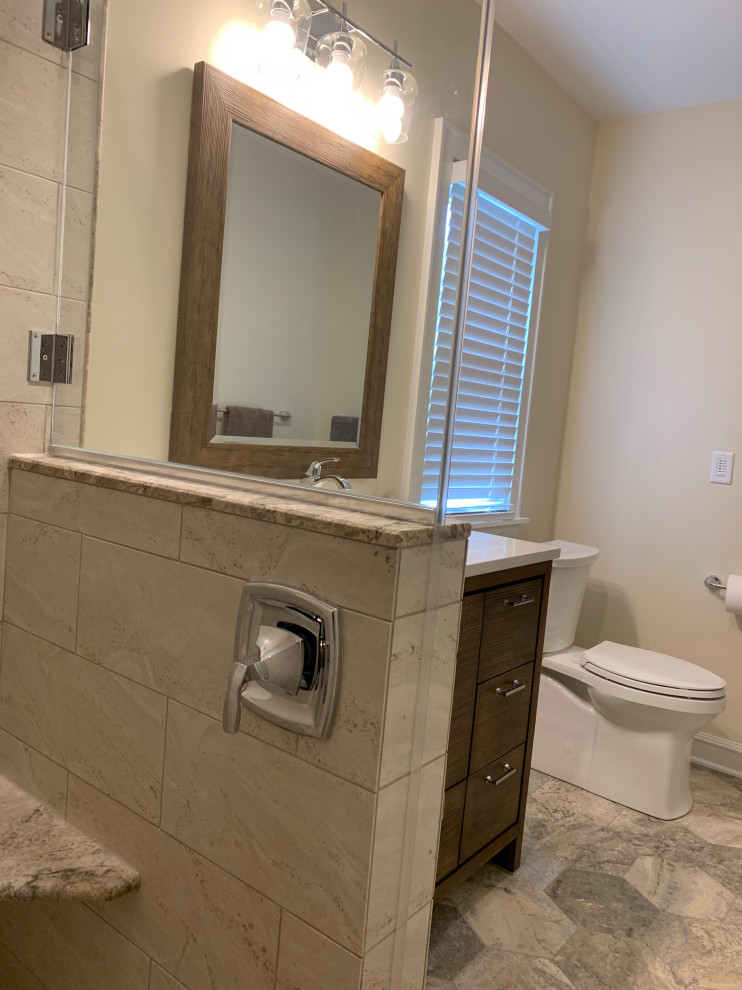 This is an example of a medium sized modern bathroom in Milwaukee with flat-panel cabinets, medium wood cabinets, a walk-in shower, a two-piece toilet, grey tiles, limestone tiles, limestone flooring, a submerged sink, engineered stone worktops, grey floors, a hinged door and white worktops.
