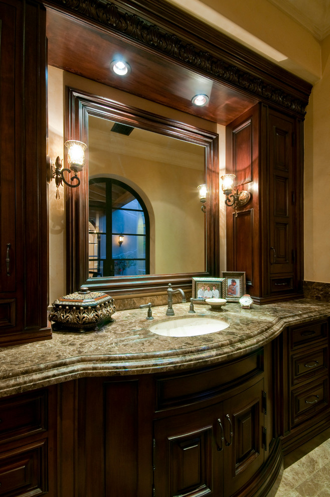 Klassisk inredning av ett mycket stort badrum med dusch, med släta luckor, skåp i mellenmörkt trä, ett fristående badkar, en dubbeldusch, en toalettstol med separat cisternkåpa, vit kakel, marmorkakel, beige väggar, klinkergolv i porslin, ett fristående handfat och marmorbänkskiva