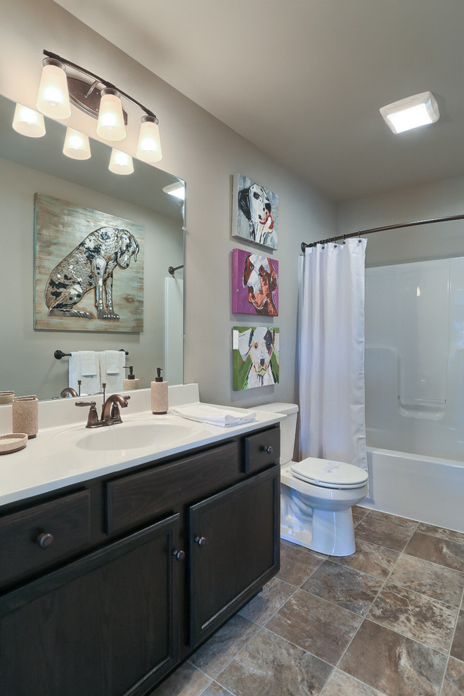 Ejemplo de cuarto de baño tradicional de tamaño medio con armarios con paneles empotrados, puertas de armario de madera en tonos medios, bañera empotrada, combinación de ducha y bañera, paredes beige y lavabo integrado