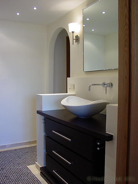 Design ideas for a small contemporary ensuite bathroom in Other with freestanding cabinets, dark wood cabinets, wooden worktops, a two-piece toilet, white tiles, porcelain tiles, white walls, porcelain flooring, a vessel sink and multi-coloured floors.