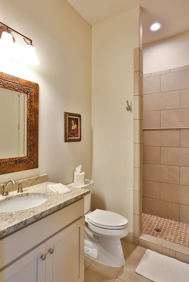 Inspiration for a mid-sized timeless kids' white tile and cement tile cement tile floor and white floor bathroom remodel in Austin with recessed-panel cabinets, beige cabinets, a two-piece toilet, white walls, an undermount sink, granite countertops and multicolored countertops