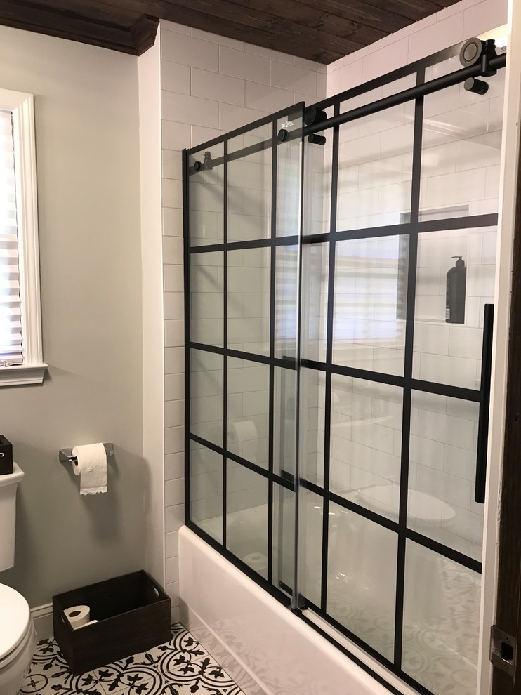 Bathroom - mid-sized transitional white tile and subway tile ceramic tile and black floor bathroom idea in Atlanta with furniture-like cabinets, black cabinets, a two-piece toilet, gray walls, an undermount sink, quartz countertops and white countertops
