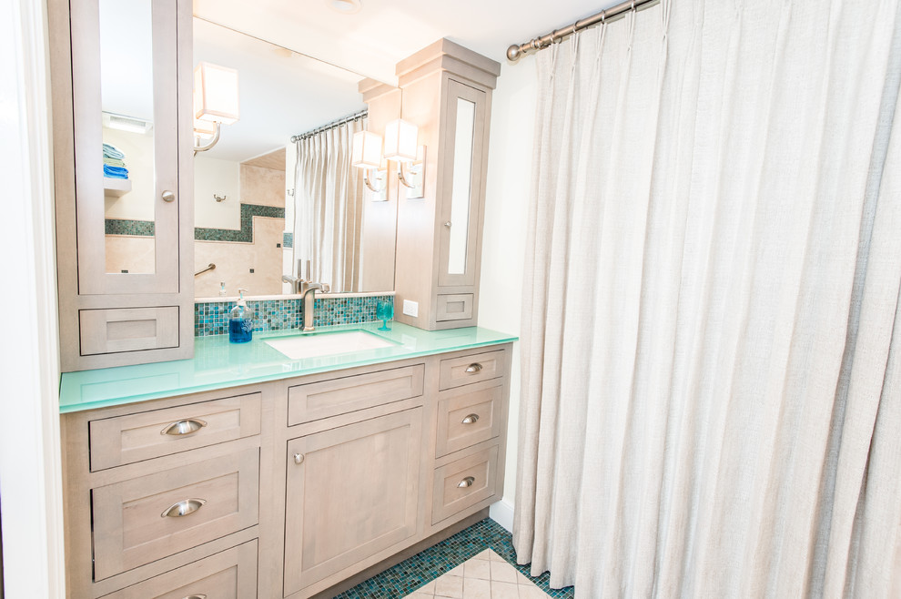 Свежая идея для дизайна: большая главная ванная комната в морском стиле с фасадами в стиле шейкер, светлыми деревянными фасадами, ванной в нише, душем в нише, раздельным унитазом, синей плиткой, плиткой мозаикой, бежевыми стенами, полом из мозаичной плитки, врезной раковиной, стеклянной столешницей и шторкой для ванной - отличное фото интерьера