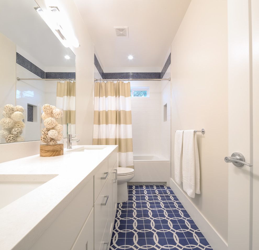 Example of a mid-sized transitional kids' ceramic tile and white tile concrete floor and blue floor bathroom design in Denver with shaker cabinets, white cabinets, a one-piece toilet, gray walls, an undermount sink and quartz countertops