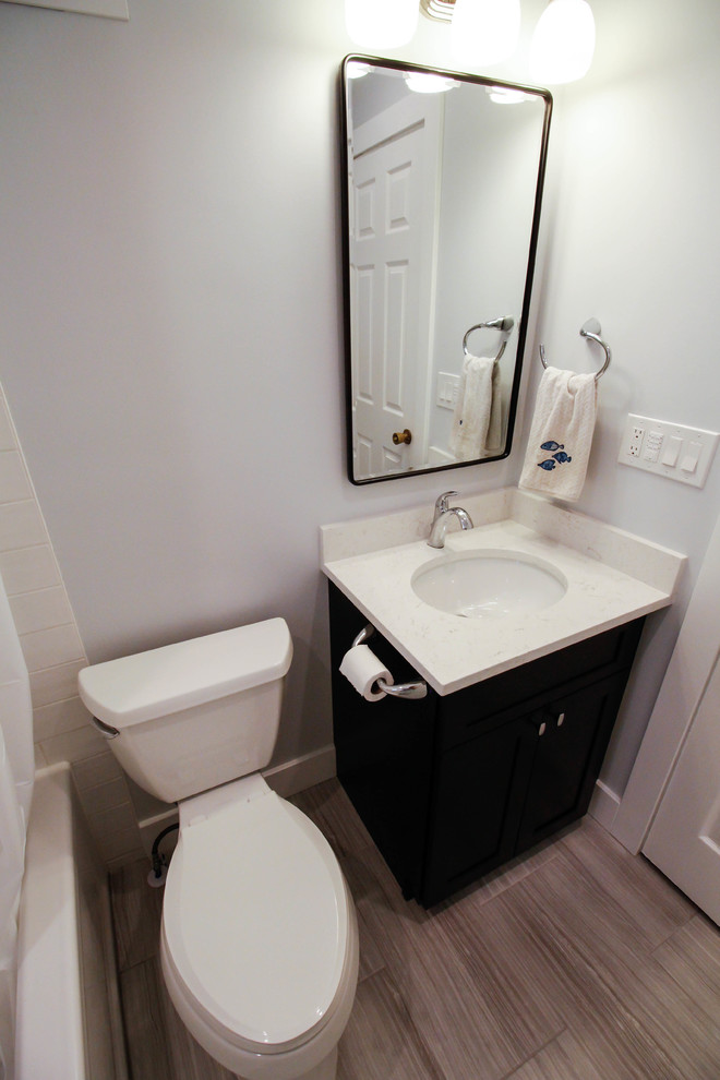 Aménagement d'une petite salle de bain classique en bois foncé pour enfant avec un placard à porte shaker, une baignoire en alcôve, un combiné douche/baignoire, WC séparés, un carrelage blanc, un carrelage métro, un mur violet, un sol en carrelage de porcelaine, un lavabo encastré, un plan de toilette en quartz modifié, un sol gris, une cabine de douche avec un rideau et un plan de toilette blanc.