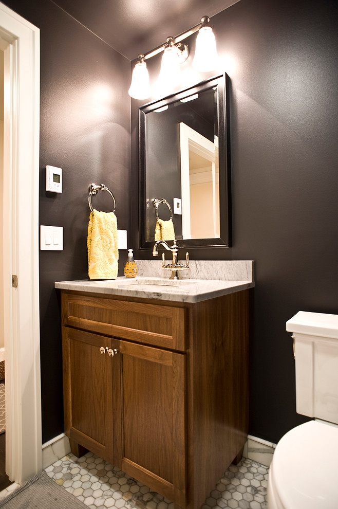 Diseño de cuarto de baño tradicional renovado con lavabo bajoencimera, armarios con paneles empotrados, puertas de armario de madera en tonos medios, sanitario de dos piezas y paredes negras