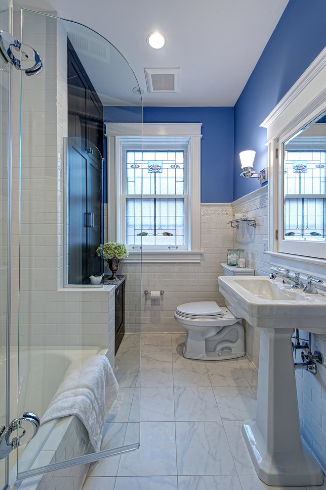 На фото: ванная комната среднего размера в морском стиле с раковиной с пьедесталом, темными деревянными фасадами, ванной в нише, душем над ванной, раздельным унитазом, белой плиткой, плиткой кабанчик, фасадами в стиле шейкер, полом из керамической плитки, душевой кабиной, белым полом, душем с распашными дверями и синими стенами с