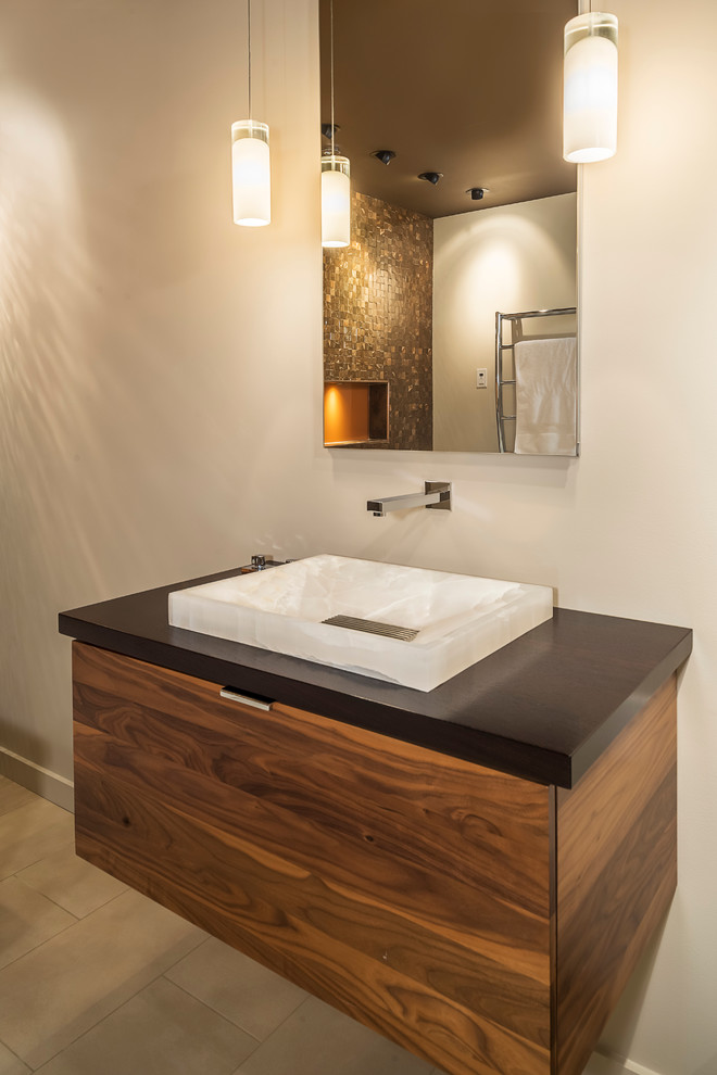 Example of a mid-sized trendy brown tile and ceramic tile porcelain tile and beige floor bathroom design in Chicago with furniture-like cabinets, medium tone wood cabinets, a wall-mount toilet, white walls, a vessel sink and wood countertops