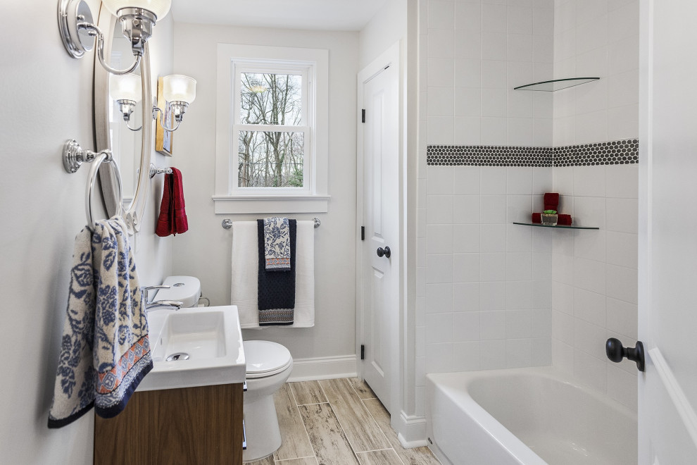 На фото: главная ванная комната среднего размера в классическом стиле с плоскими фасадами, коричневыми фасадами, ванной в нише, душем в нише, раздельным унитазом, белой плиткой, керамической плиткой, белыми стенами, полом из керамической плитки, монолитной раковиной, столешницей из искусственного камня, серым полом, шторкой для ванной, белой столешницей, тумбой под одну раковину и напольной тумбой с
