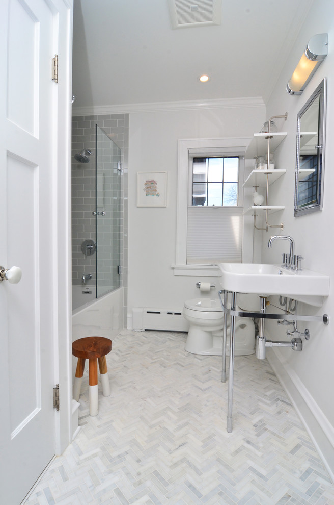 ニューヨークにある小さなトランジショナルスタイルのおしゃれな浴室 (オープンシェルフ、アルコーブ型浴槽、シャワー付き浴槽	、分離型トイレ、グレーのタイル、サブウェイタイル、白い壁、大理石の床、コンソール型シンク) の写真