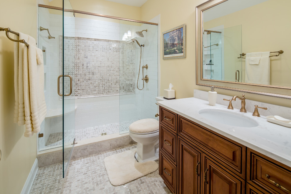 Inspiration for a medium sized traditional ensuite bathroom in Atlanta with raised-panel cabinets, dark wood cabinets, an alcove shower, a two-piece toilet, yellow walls, porcelain flooring, a submerged sink and engineered stone worktops.