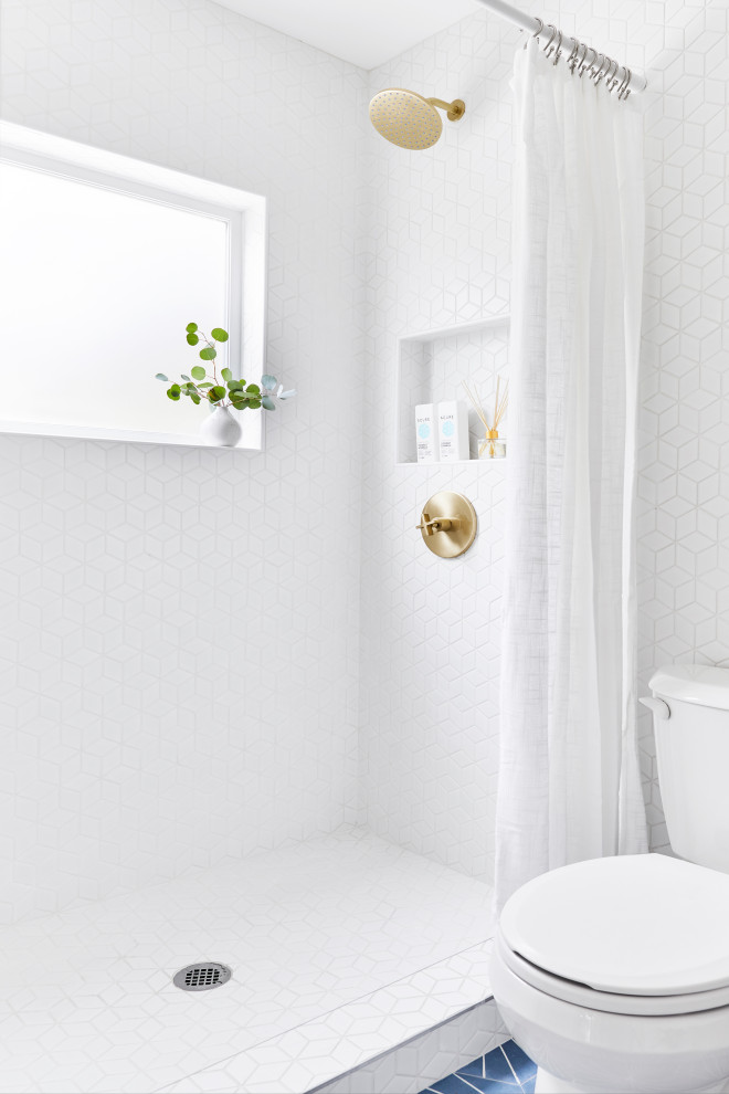 Inspiration for a small coastal shower room bathroom in Los Angeles with open cabinets, blue cabinets, a corner shower, a one-piece toilet, white tiles, ceramic tiles, white walls, cement flooring, a wall-mounted sink, blue floors, a shower curtain and white worktops.