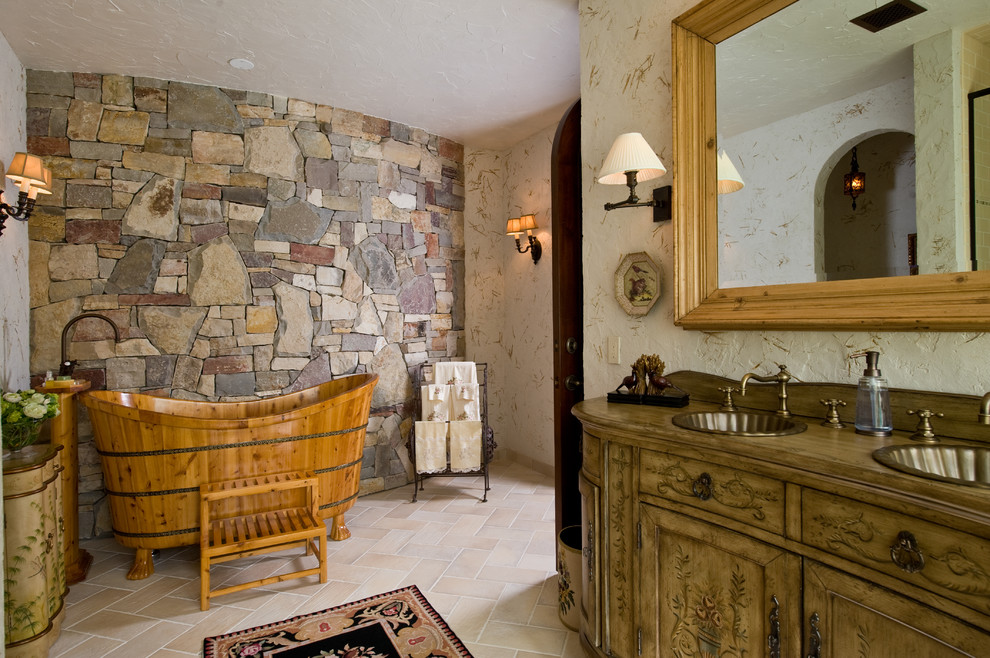 Diseño de cuarto de baño principal mediterráneo con armarios tipo mueble, puertas de armario con efecto envejecido, bañera exenta, baldosas y/o azulejos beige y paredes beige