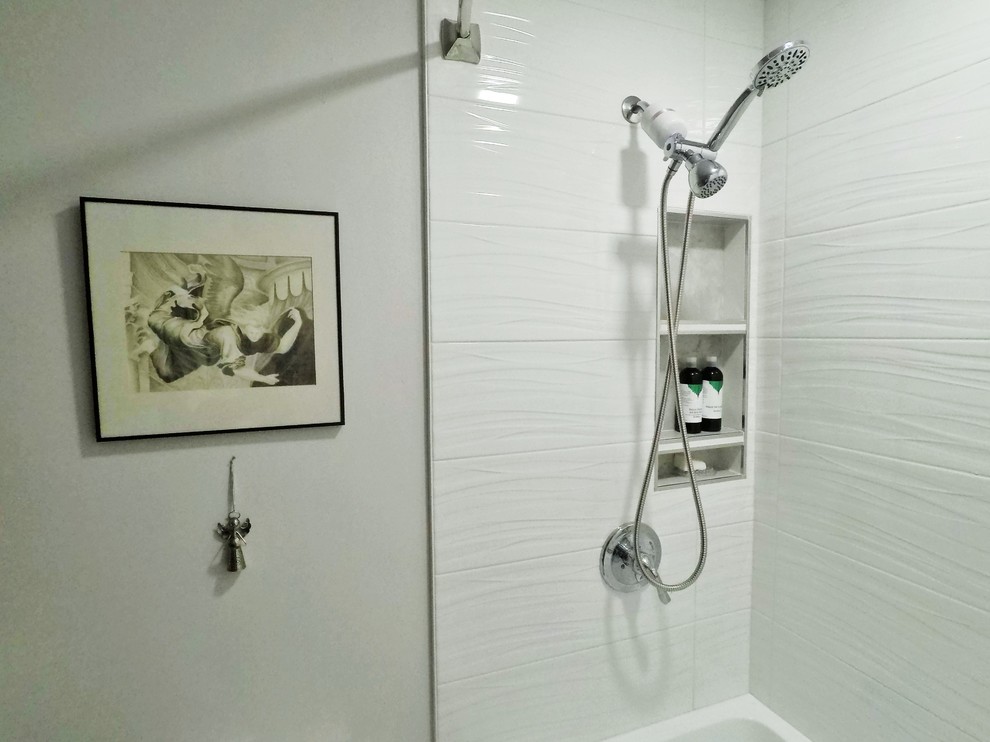 Modern inredning av ett mellanstort vit vitt badrum med dusch, med släta luckor, grå skåp, ett badkar i en alkov, en dusch/badkar-kombination, en toalettstol med hel cisternkåpa, vit kakel, keramikplattor, grå väggar, klinkergolv i porslin, ett avlångt handfat, bänkskiva i akrylsten, grått golv och dusch med duschdraperi