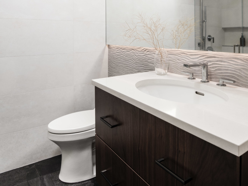 Example of a small trendy 3/4 gray tile and porcelain tile porcelain tile and gray floor bathroom design in Seattle with flat-panel cabinets, dark wood cabinets, a one-piece toilet, white walls, an undermount sink, quartz countertops, a hinged shower door and white countertops
