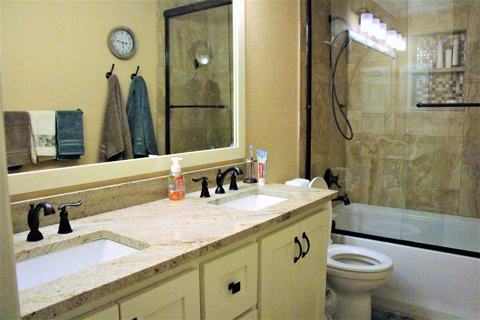 Réalisation d'une salle de bain chalet de taille moyenne pour enfant avec un placard à porte shaker, des portes de placard blanches, une baignoire encastrée, un combiné douche/baignoire, WC à poser, un carrelage marron, des carreaux de céramique, un mur beige, sol en béton ciré, un lavabo encastré, un plan de toilette en granite, un sol marron et une cabine de douche à porte coulissante.
