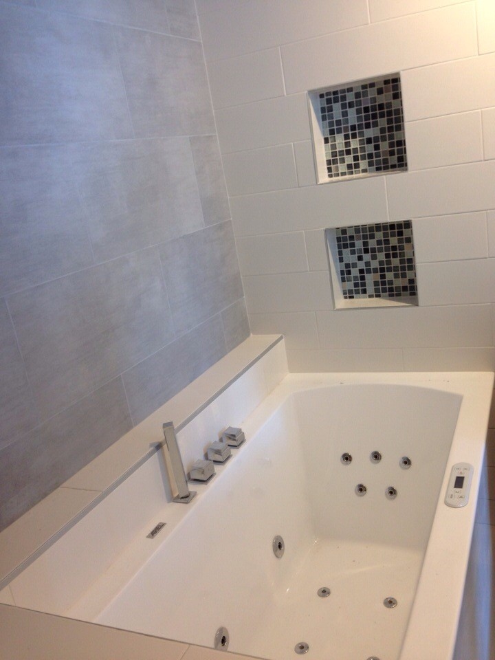 Idéer för att renovera ett mellanstort funkis en-suite badrum, med ett nedsänkt handfat, släta luckor, skåp i ljust trä, bänkskiva i kvarts, ett badkar i en alkov, en dusch i en alkov, en toalettstol med hel cisternkåpa, grå kakel, porslinskakel, vita väggar och klinkergolv i porslin