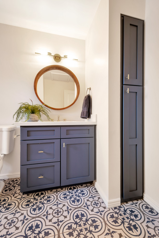 Пример оригинального дизайна: маленькая детская ванная комната в стиле неоклассика (современная классика) с фасадами в стиле шейкер, синими фасадами, ванной в нише, душем над ванной, белой плиткой, плиткой кабанчик, серыми стенами, полом из керамогранита, врезной раковиной, столешницей из искусственного кварца, синим полом, шторкой для ванной, белой столешницей, тумбой под одну раковину и встроенной тумбой для на участке и в саду