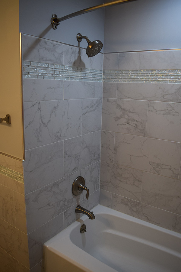 Inspiration for a mid-sized timeless master gray tile and ceramic tile laminate floor and gray floor bathroom remodel in DC Metro with raised-panel cabinets, dark wood cabinets, a two-piece toilet, gray walls, an undermount sink and quartz countertops