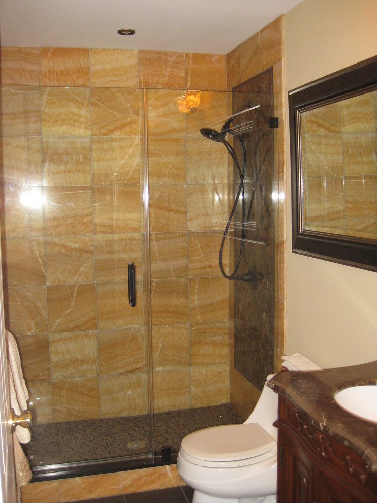 Immagine di una stanza da bagno classica di medie dimensioni con lavabo sottopiano, consolle stile comò, ante in legno scuro, top in granito, doccia doppia, WC monopezzo, piastrelle gialle, piastrelle in pietra, pareti beige e pavimento in marmo