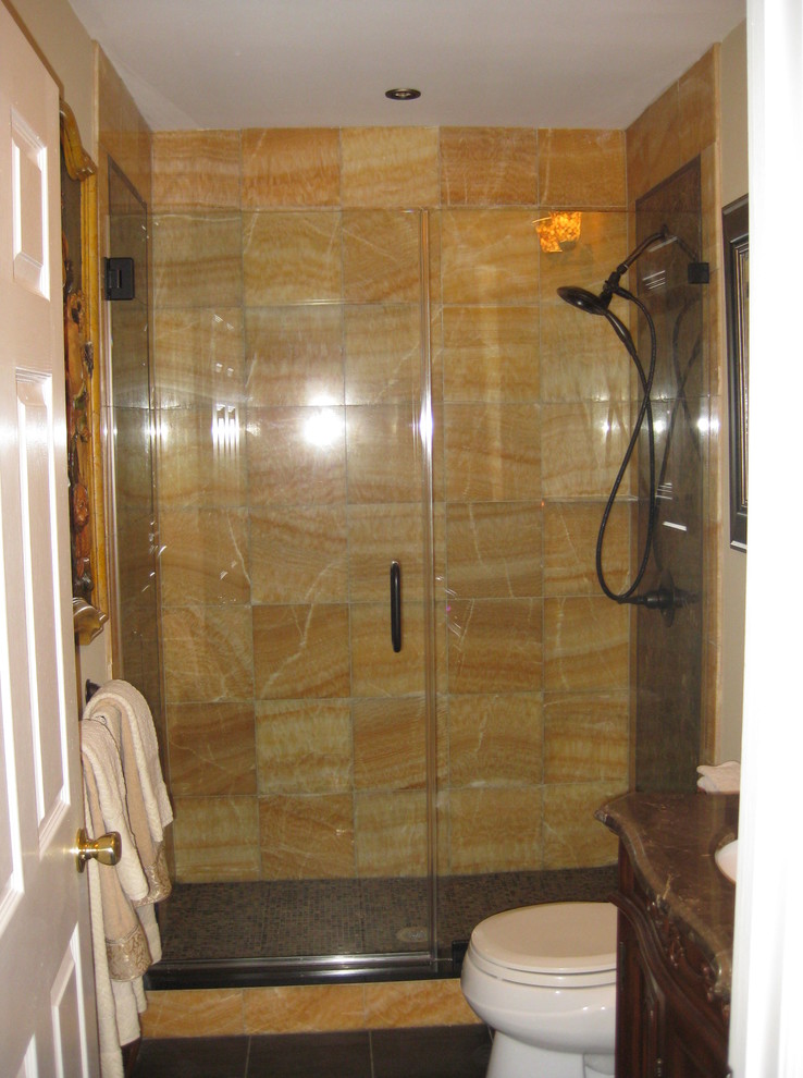 Immagine di una stanza da bagno tradizionale di medie dimensioni con lavabo sottopiano, top in granito, doccia doppia, WC monopezzo, piastrelle gialle, piastrelle in pietra, pareti beige e pavimento in marmo