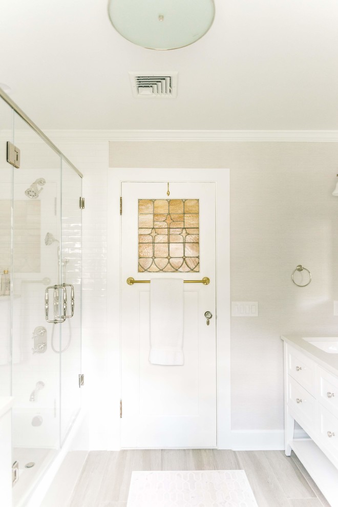 Inredning av ett klassiskt mellanstort vit vitt badrum, med skåp i shakerstil, vita skåp, ett hörnbadkar, en dusch/badkar-kombination, vit kakel, keramikplattor, grå väggar, klinkergolv i porslin, ett undermonterad handfat, bänkskiva i kvarts och grått golv