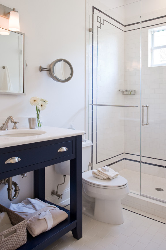 Example of a mid-sized eclectic ceramic tile and white floor alcove shower design in Tampa with furniture-like cabinets, blue cabinets, white walls, an undermount sink, solid surface countertops and a hinged shower door
