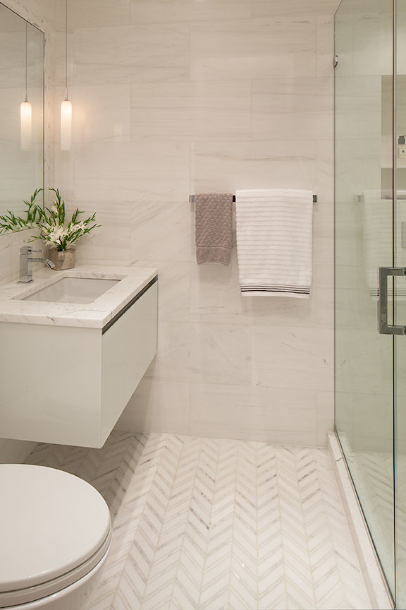 Design ideas for a small contemporary shower room bathroom in New York with a submerged sink, flat-panel cabinets, white cabinets, marble worktops, an alcove shower, a one-piece toilet, white tiles, stone tiles, white walls and marble flooring.
