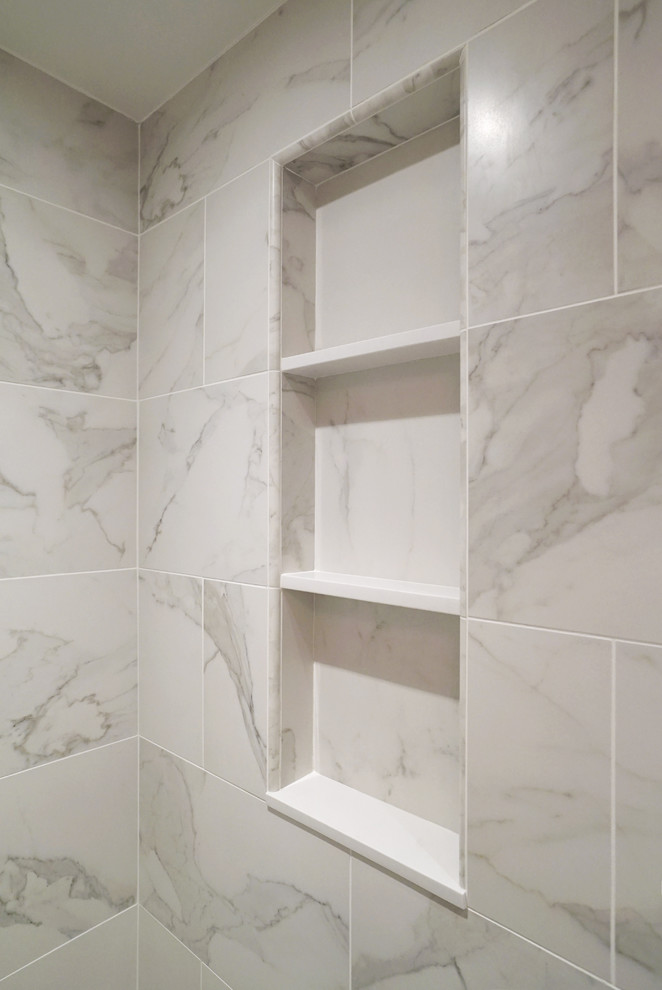 Klassisk inredning av ett litet en-suite badrum, med en dusch i en alkov, en toalettstol med hel cisternkåpa, vit kakel, porslinskakel, vita väggar, klinkergolv i porslin och ett piedestal handfat