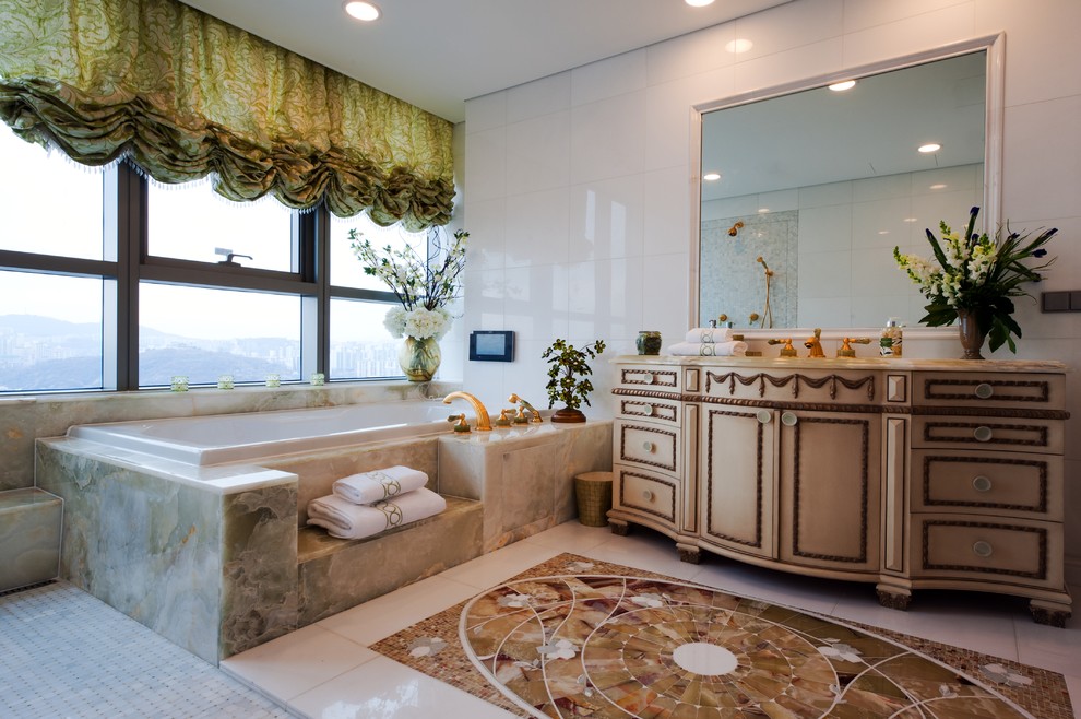 This is an example of a classic bathroom in New York with beige cabinets, a built-in bath, white tiles and recessed-panel cabinets.