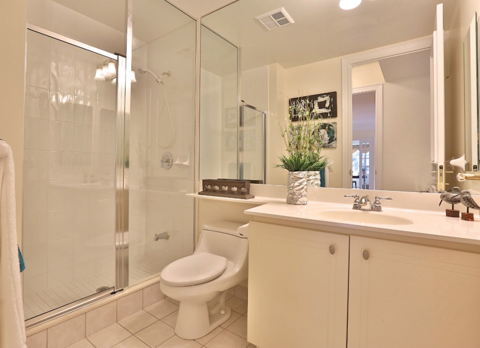 Inspiration for a medium sized traditional shower room bathroom in Toronto with an integrated sink, white cabinets, beige tiles, beige walls, ceramic flooring, recessed-panel cabinets, laminate worktops, an alcove shower, a one-piece toilet, ceramic tiles and beige floors.