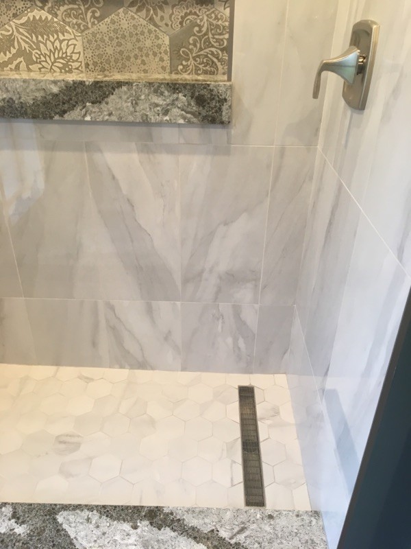 Foto på ett mellanstort funkis en-suite badrum, med skåp i shakerstil, vita skåp, en dusch i en alkov, grå kakel, porslinskakel, blå väggar, klinkergolv i porslin, bänkskiva i kvarts, grått golv och dusch med gångjärnsdörr