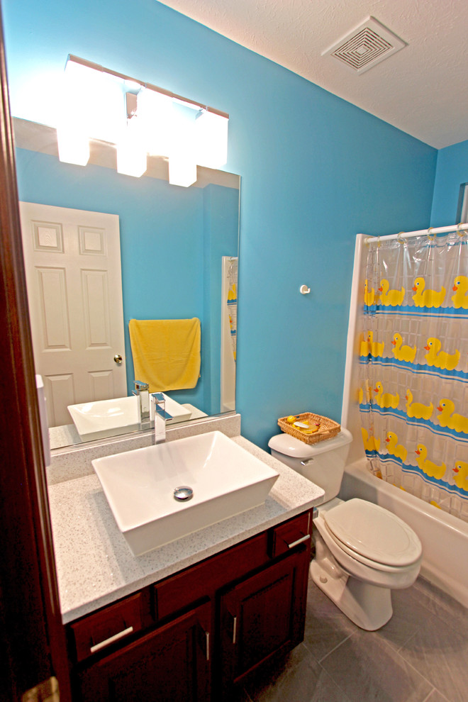 Inredning av ett klassiskt litet badrum med dusch, med luckor med upphöjd panel, skåp i mörkt trä, blå väggar, klinkergolv i porslin, ett fristående handfat och bänkskiva i kvarts